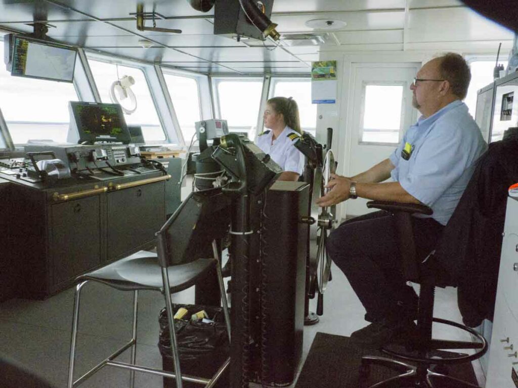 In the pilothouse, Able Bodied Seaman Blaire Leeson, a Haweater, at the wheel, and Chief Mate Kelsey Wade ensure safe, on-schedule crossings of the Chi-Cheemaun to and from South Baymouth and Tobermory. Photo by Isobel Harry