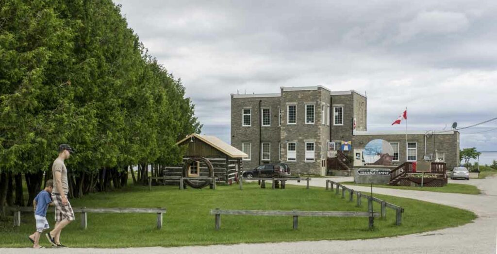 A tiny log cabin (left), housing the Post Office Museum of early Manitoulin Transportation and Communication, is a mini-museum to peek in at the Old Mill Heritage Centre in Kagawong.  Photos by Isobel Harry.