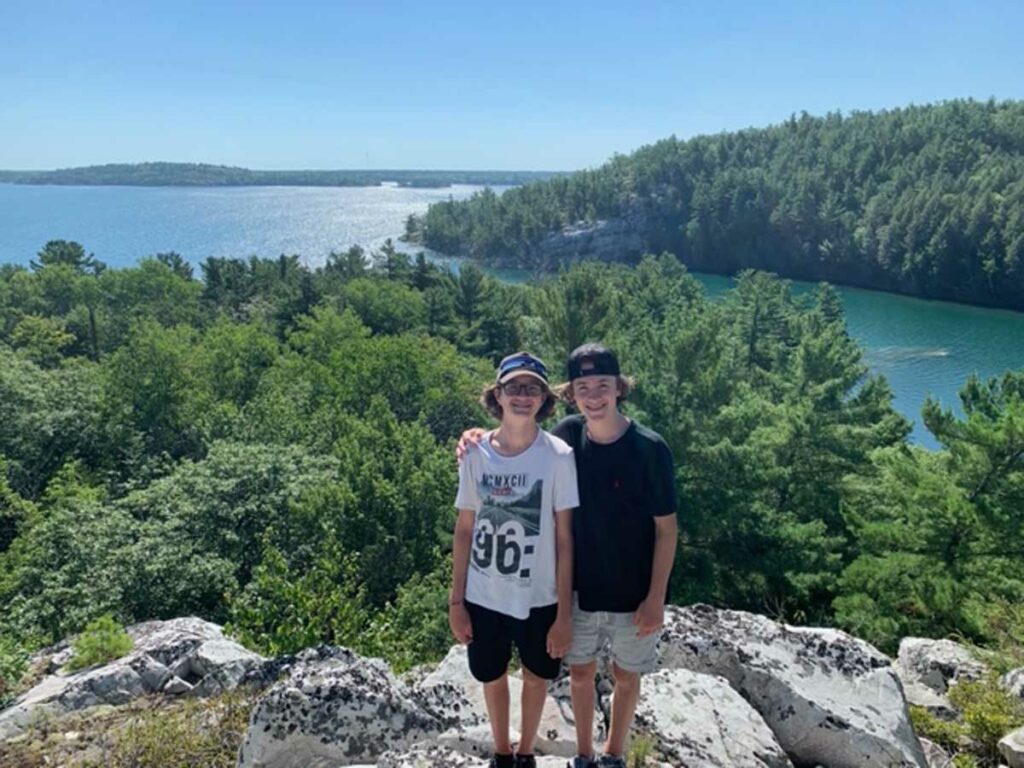 Bob and Kathy Hall’s grandsons, Emmett, left, and Owen, clamber ashore in the spectacular landscape of a North Channel cove. Photo by Isobel Harry.