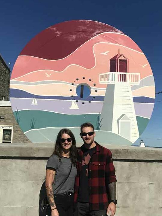 Stephanie and Troy Rubach from Red Rock, ON. posed infront of the newly decorated flywheel mural.