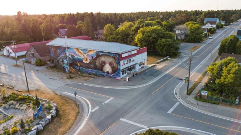 The iconic 1930s McDermid’s hardware store in the centre of the village of Providence Bay was converted to the Mutchmor in 2016. A vibrantly-coloured mural covers the south wall, facing the newly refurbished village square. Photo by Chris Hurd (@churdphoto)