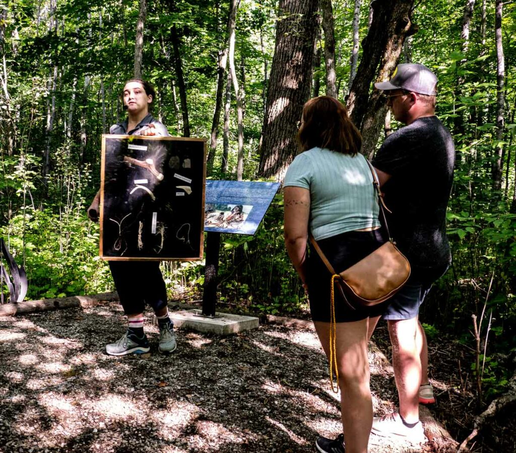 Tour guide Olivia Fetterly (left) discusses some of the artifacts found by archaeologists during early excavations of the site in Seguiandah. Photo by Isobel Harry.