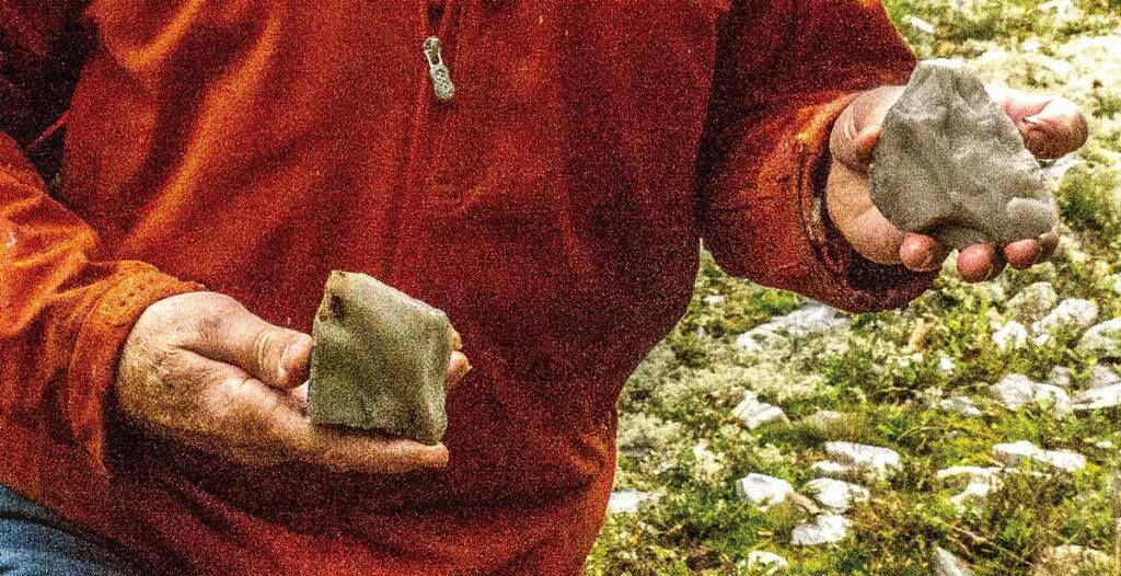 Dr. Patrick Julig picks up pieces of quartzite roughly chipped into usable tools thousands of years ago. Photo by Isobel Harry.