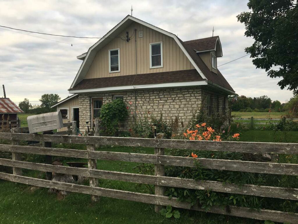 This classic gambrel-roofed farmhouse was built in 1948 by Tehkummah builder John Blackburn for his own family and is currently the home of his daughter Anne and her husband Lorne Leeson. Mr. Blackburn built several other homes in the area in the same style and always made use of local limestone as in this case. This home is located in the historic Tehkummah hamlet of Snowville at the southwest corner of Townline Road West and the 15th Sideroad. Photo by Isobel Harry.